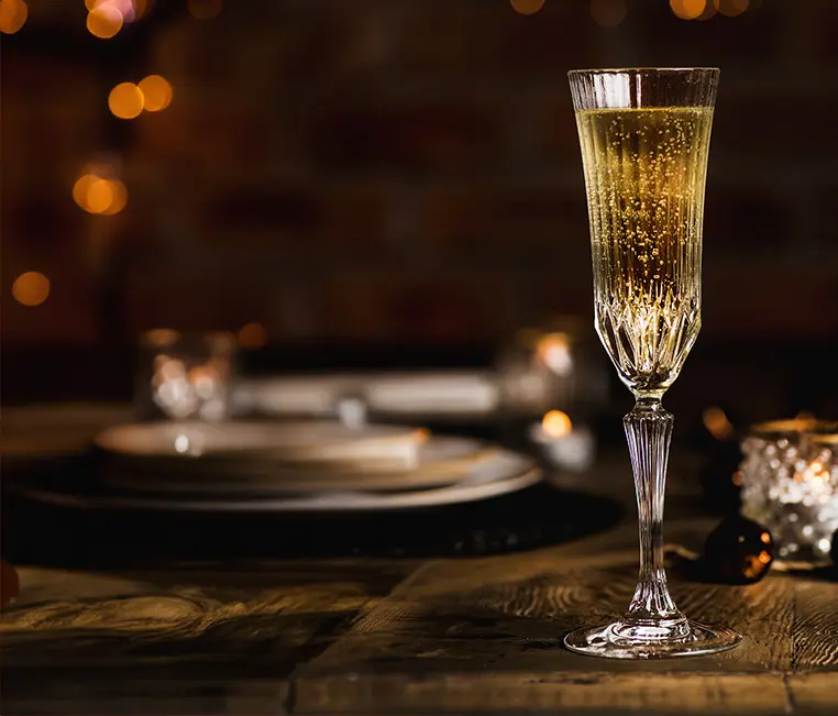 A narrow champagne glass on a rustic table.
