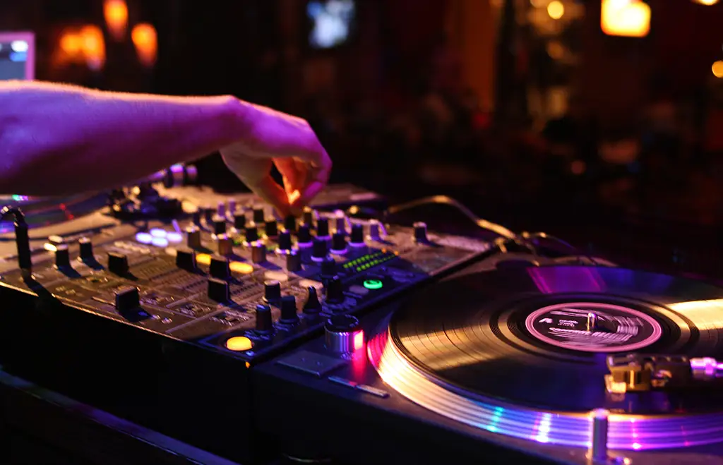 Close-up shot of a DJ turning a knob on a turntable.