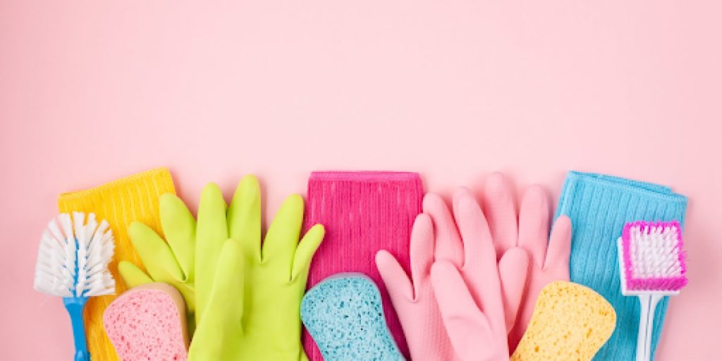 cleaning supplies on pink background