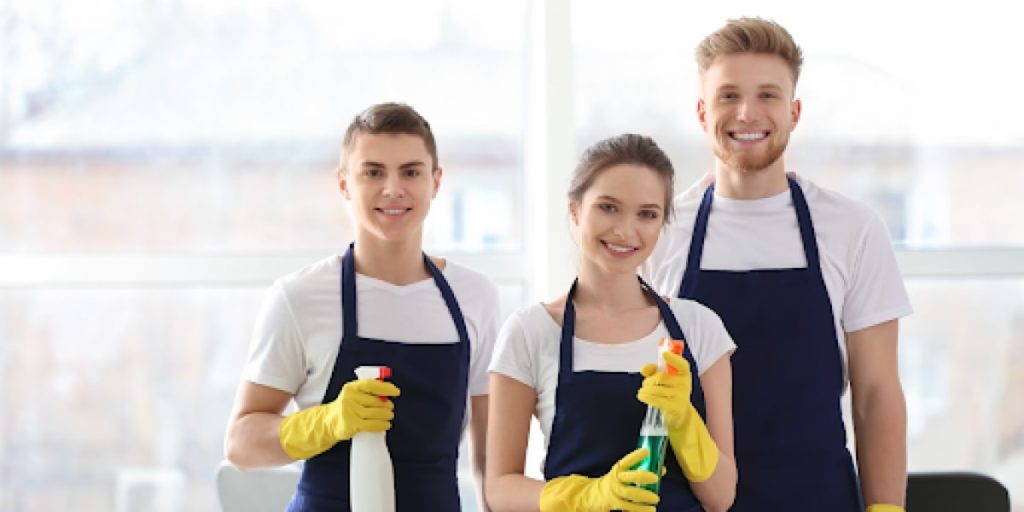 group of cleaners standing holding supplies