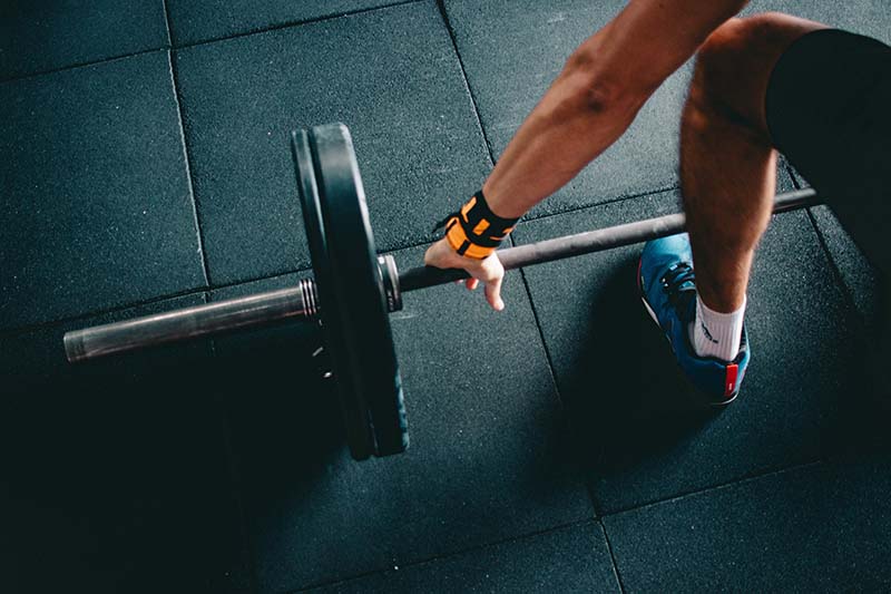 A trainer prepares to deadlift.