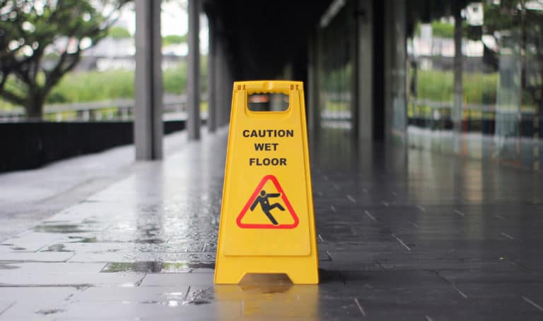 Caution wet floor signage on wet pavement