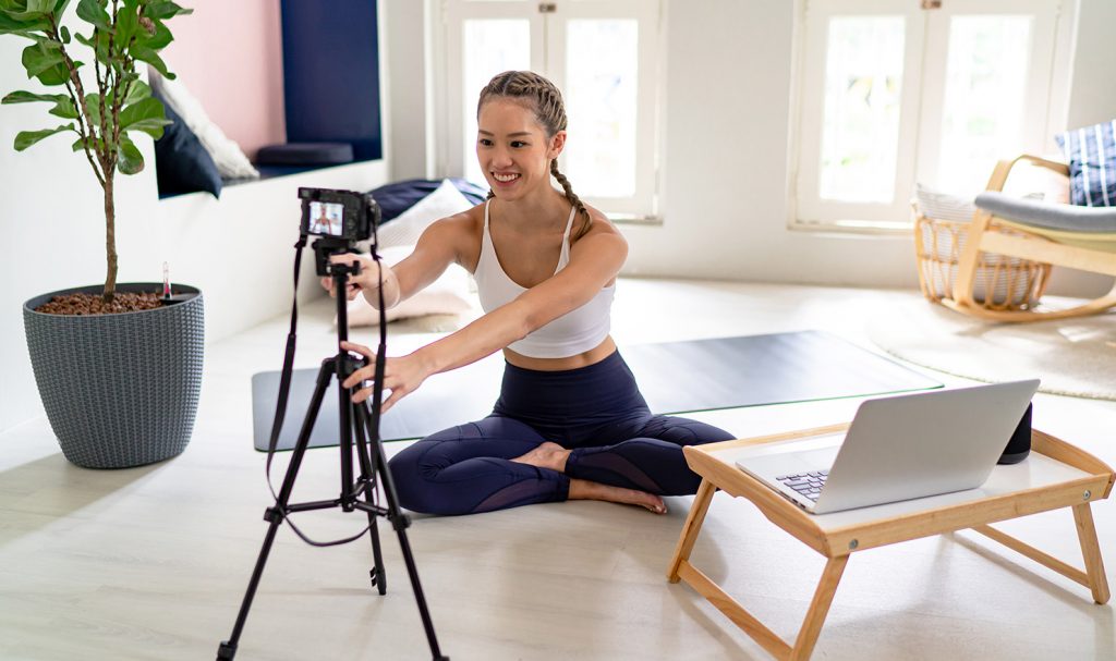 A young woman sets up her online personal training space as she prepares to meet with her clients for the day.