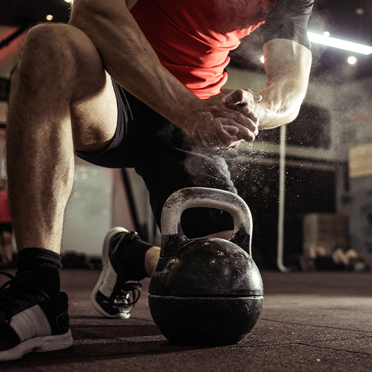 A CrossFit athlete prepares for a kettlebell exercise.