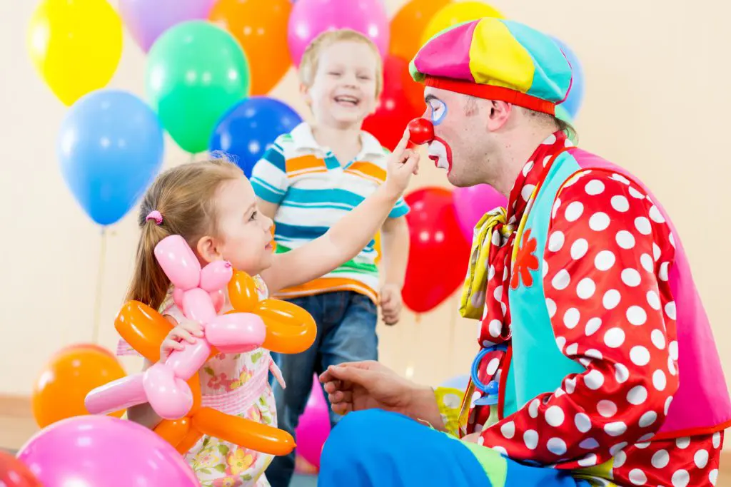 happy children and clown at birthday party