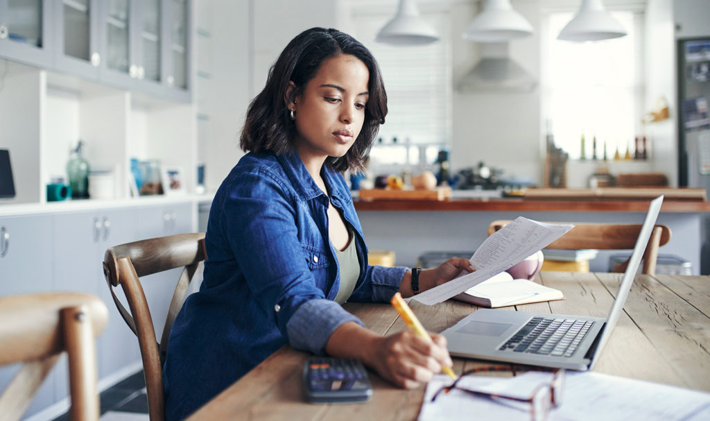 A young woman works on calculating the gross annual sales her small business so she can apply for product liability insurance.