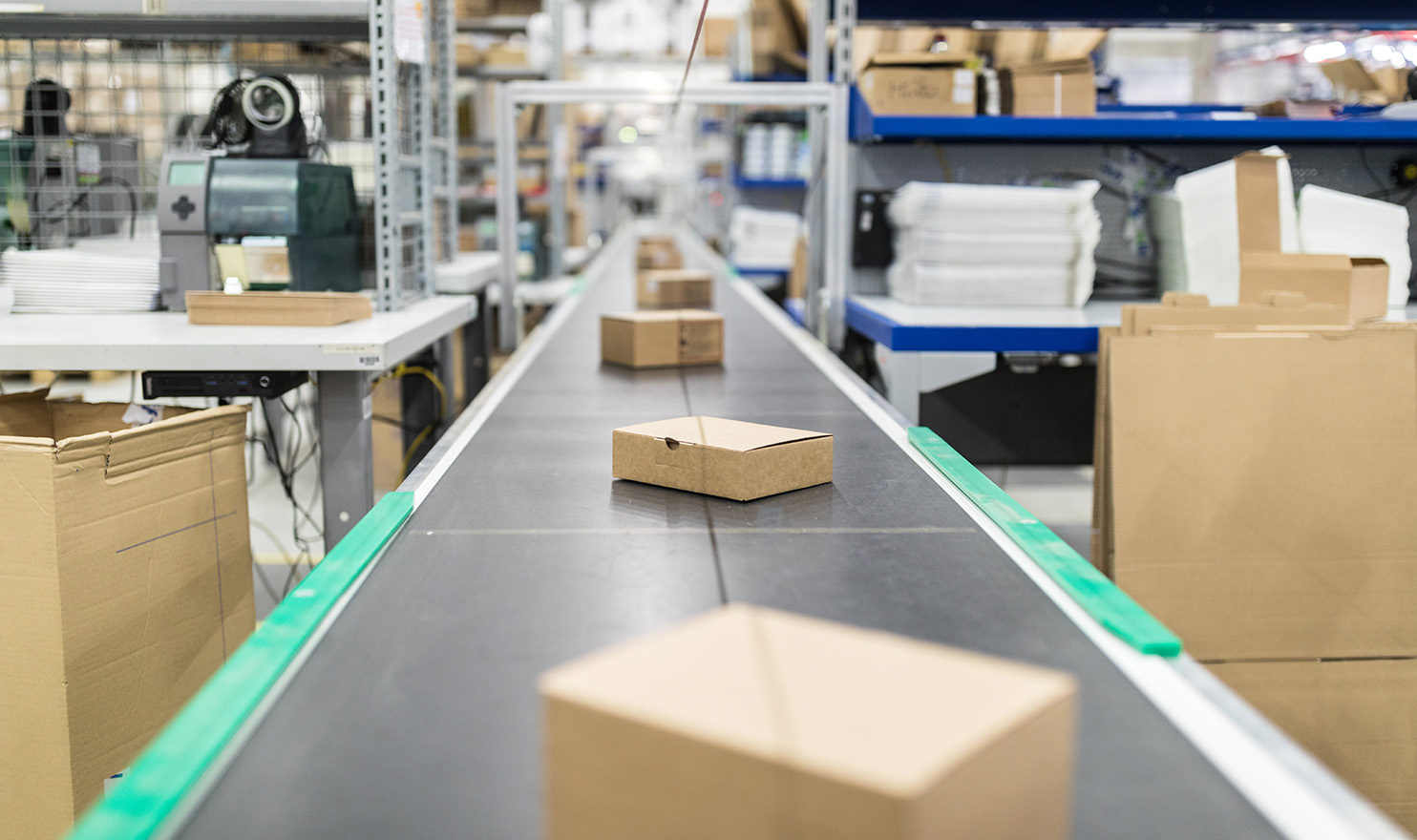 Boxes on a production line move through a warehouse using product liability insurance to insure the products they ship.