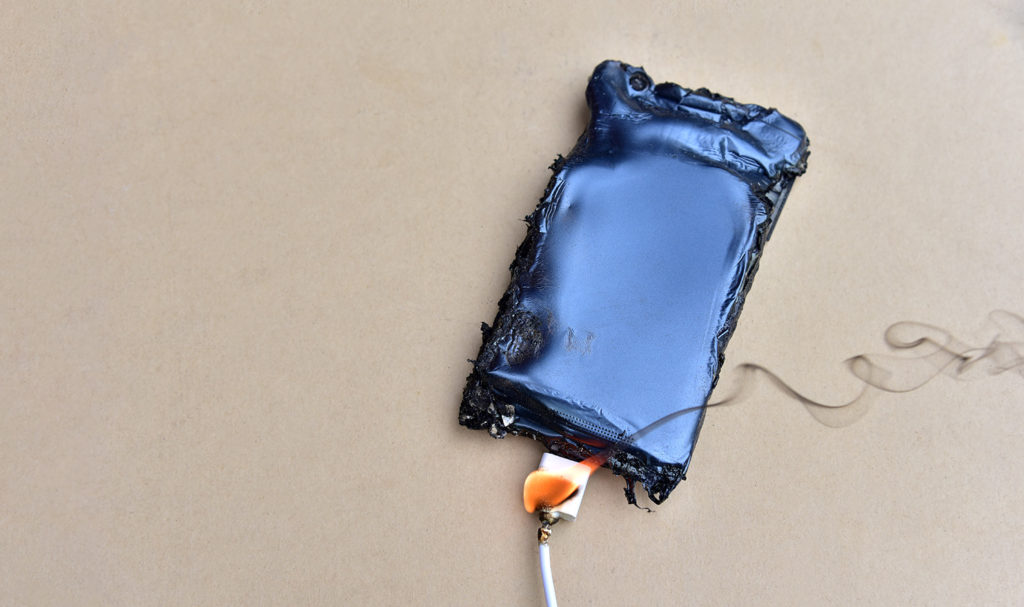 A phone is melted and broken while plugged into a charger that is on fire. Manufacturing errors on mechanical parts can lead to accidents product liability insurance may help you pay for.