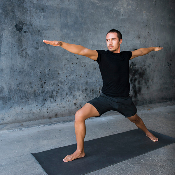 A yogi stretches wide in position on a yoga mat.