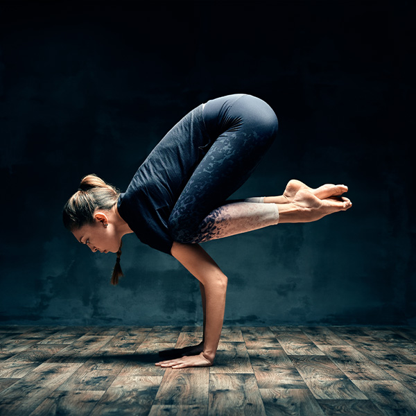A yoga teacher stands on her hands inside.