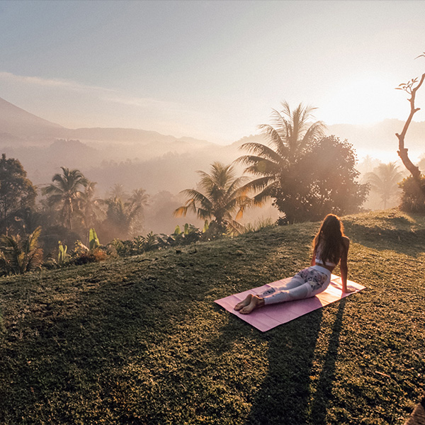 A yogi works in under a tropical sunrise.