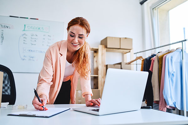 A business owner learns online and takes notes on Products And Completed Operations insurance.