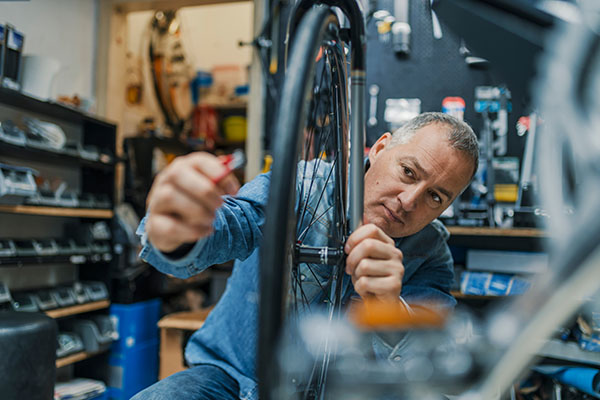 A bike shop owner works on products that have been insured with Products And Completed Operations through Insurance Canopy.