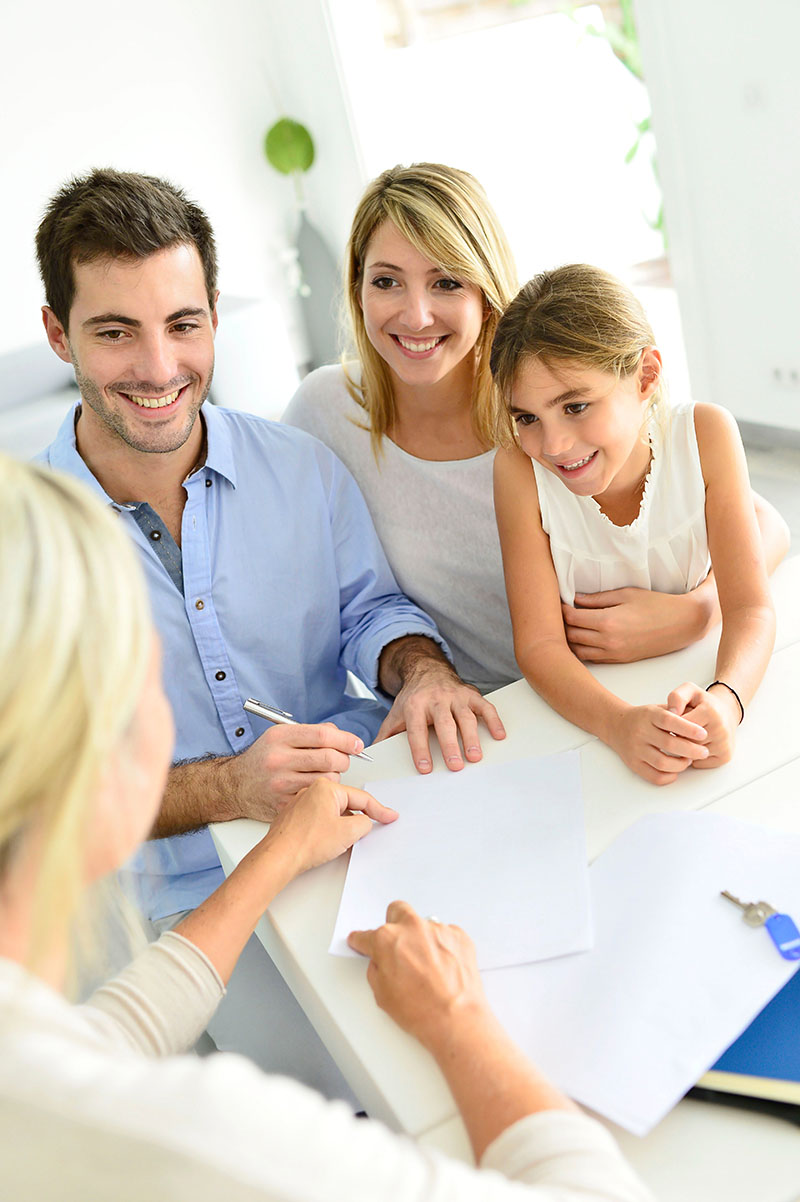 A family signs paperwork with a professional consultant who's legal advice may be insured with Professional Liability Insurance.