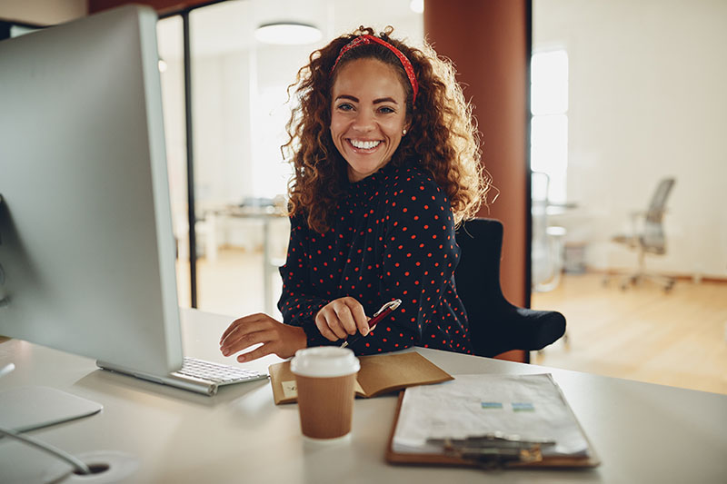 A professional smiles from her desk.