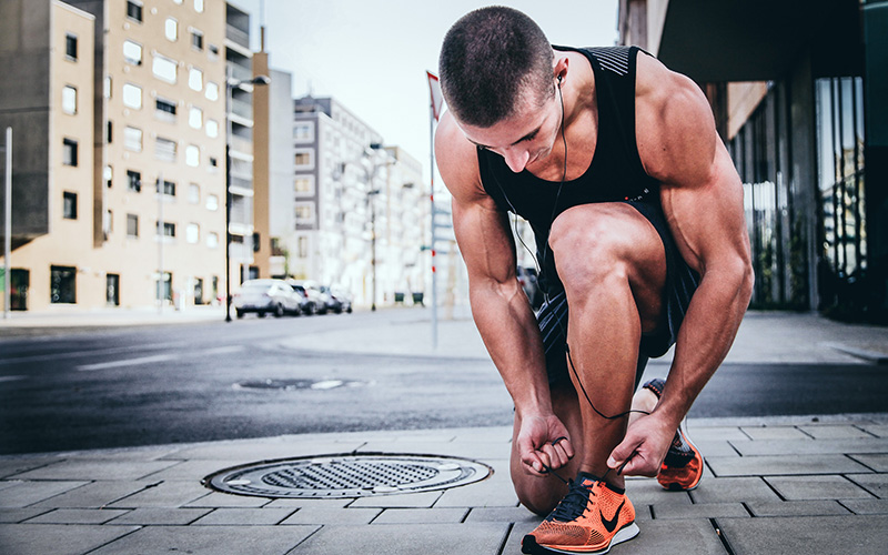 A trainer ties his shoes.