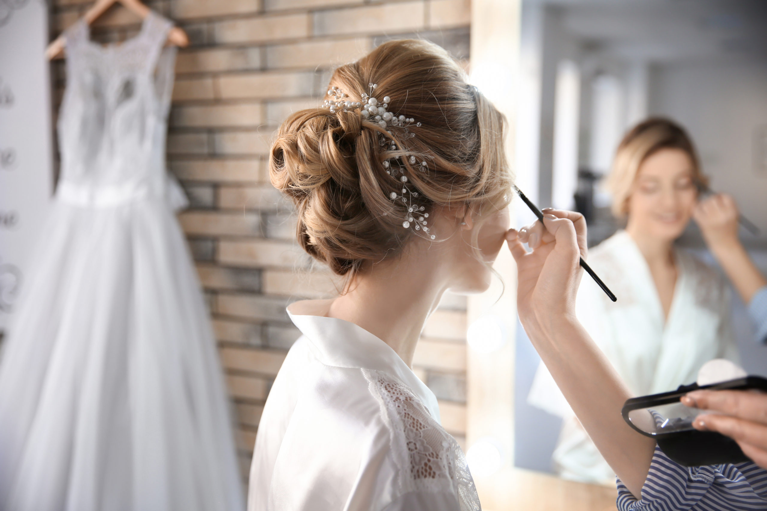 A makeup artist works on a bride's makeup before a wedding. Her inland marine insurance can protect her tools as she works from location to location.