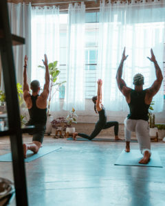A pilates class stretches together on yoga mats.