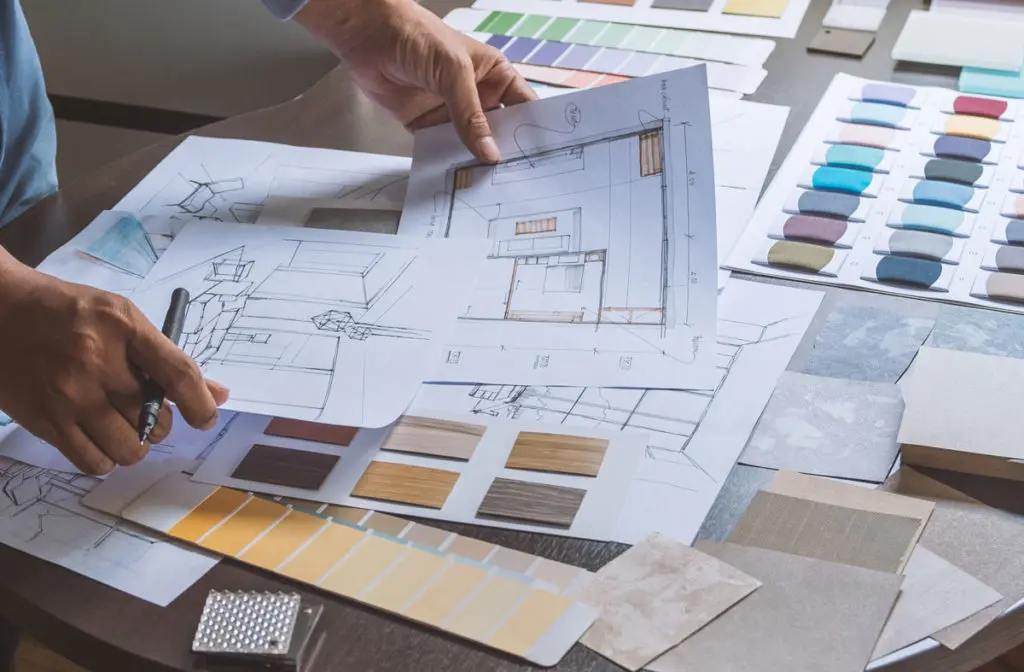 Interior designer with room layout sketches and fabric swatches