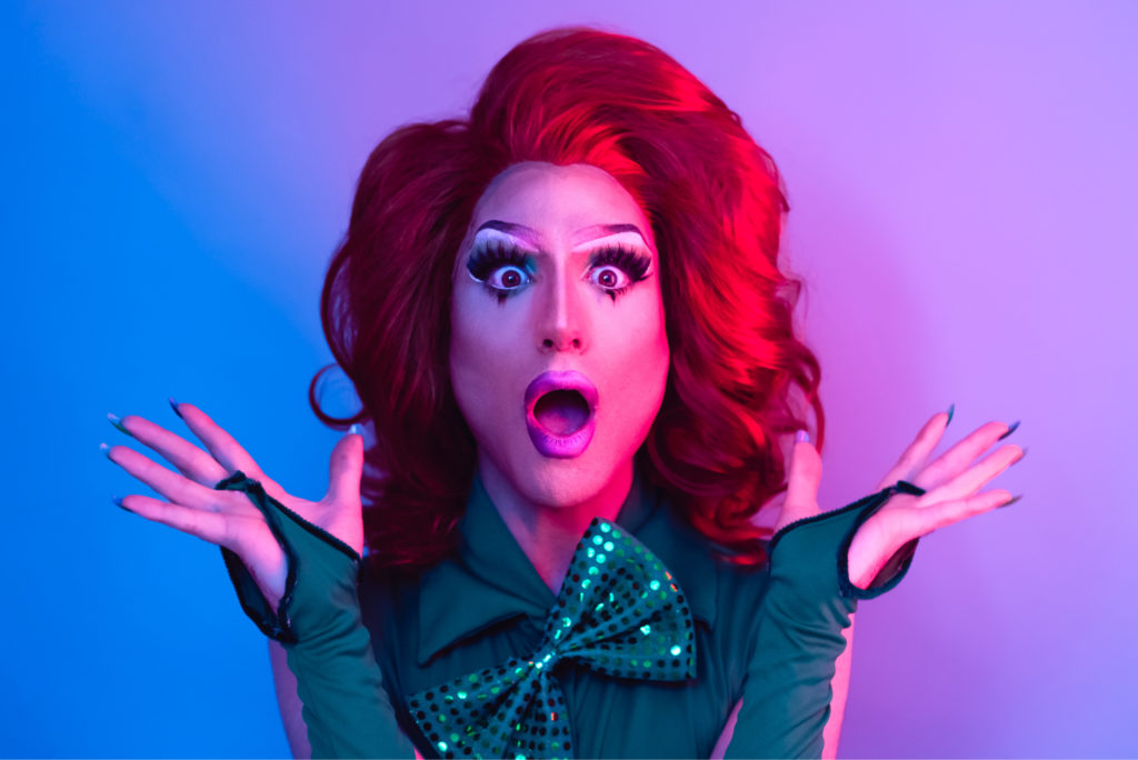 Drag queen acting surprised and happy in front of camera