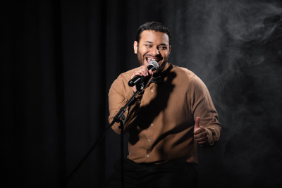 comedian laughing mid-joke on stage