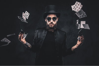 magician flipping cards with sunglasses on and a hat