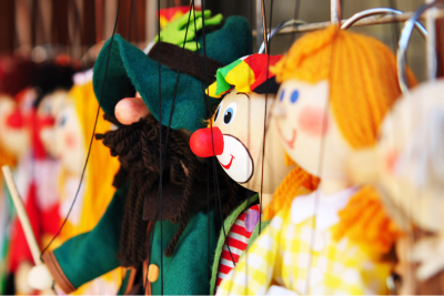 side view of several puppets or marionettes