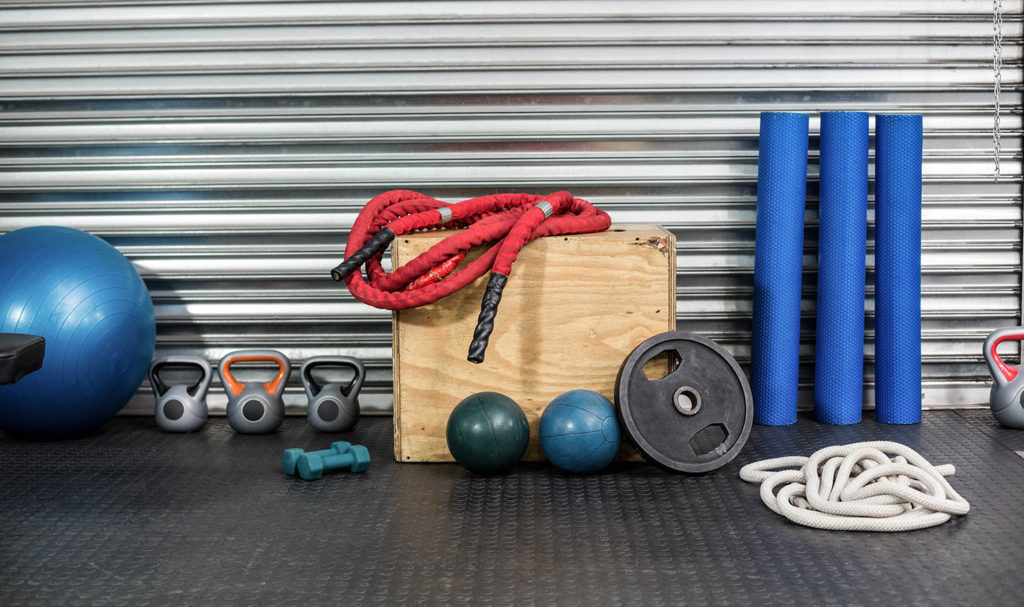 Workout equipment lined up along a wall with a silver metal background. Personal training name ideas HERO image.