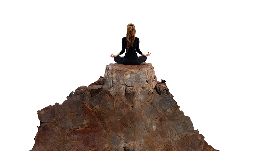 A yoga teacher is cross legged on the top of a small butte.