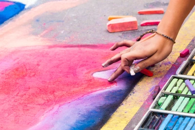 close up of hands doing chalk art on street