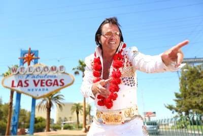 professional Elvis impersonator in front of Las Vegas sign