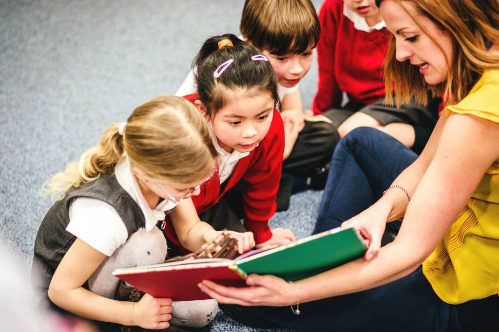 Woman reading a book to children