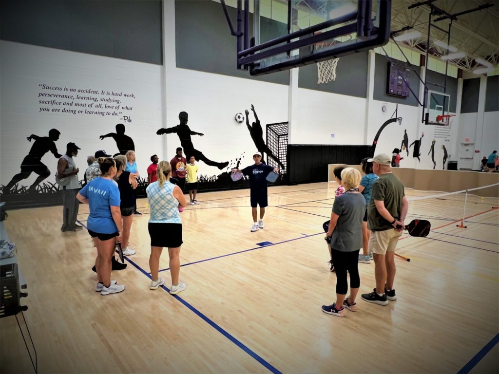 Ram teaching a group of students how to have the right form on the court to avoid injuries.