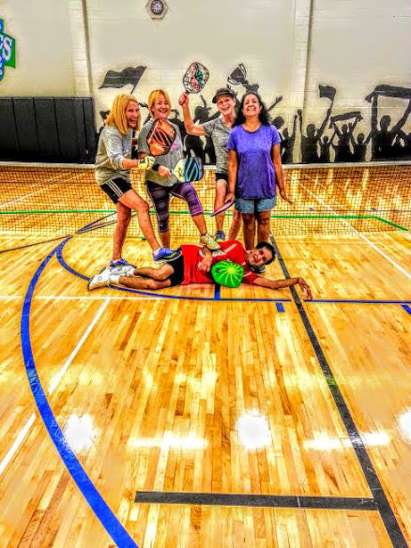 Ram laying on the court while his students strike a funny pose behind him.