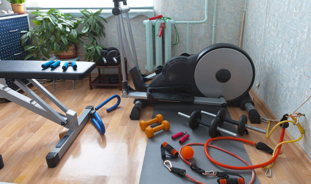 Workout gear and equipment on the ground in someone's home gym.