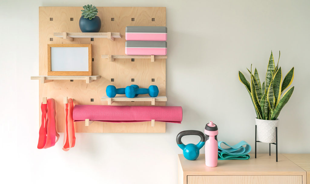 Workout equipment is displayed and organized on a wooden rack in someone's home.