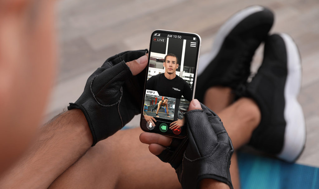 A personal trainer is uploading a video on his phone to a fitness app.