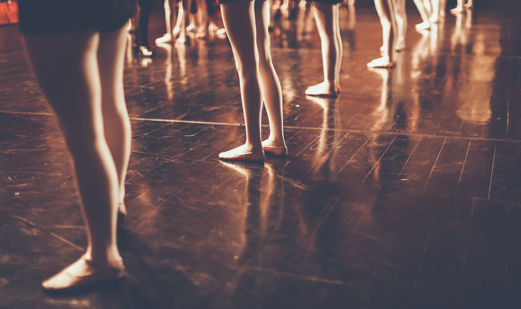 A shot of posed legs of dancers on stage.