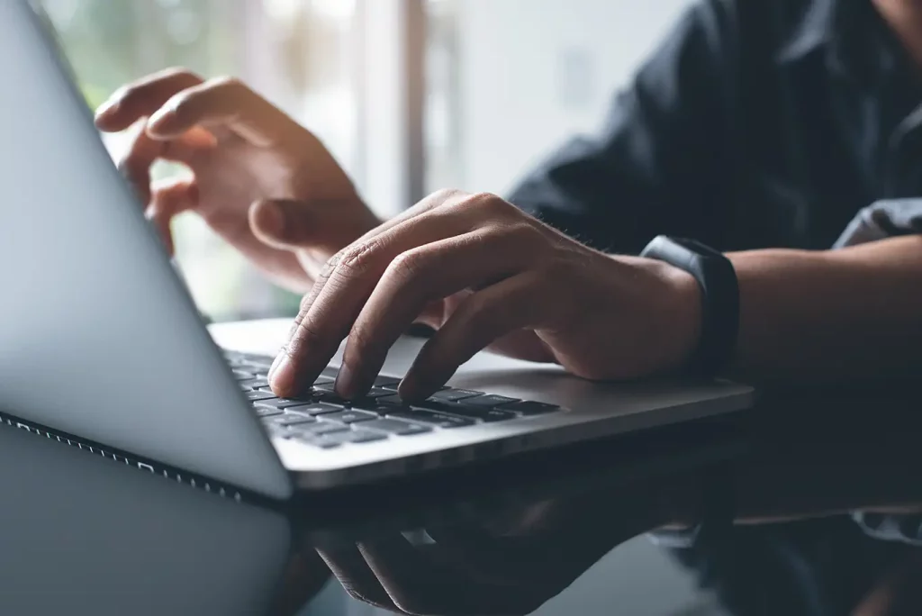 Up close image of person typing on a laptop