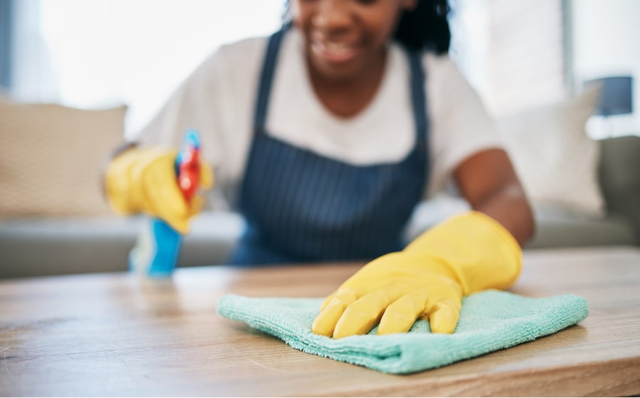 woman with cleaning gloves on scrubbing surface