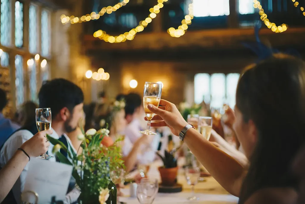 Guests raise glasses of champagne in a toast at a wedding.