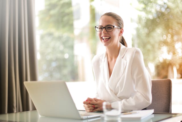woman smiling at a computer