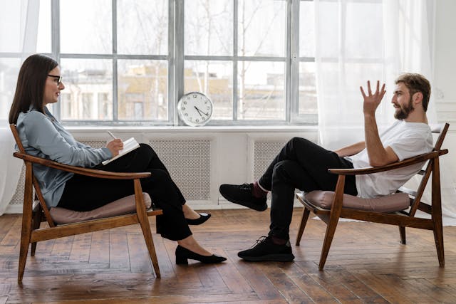 woman and man sit across from one another in deep conversation