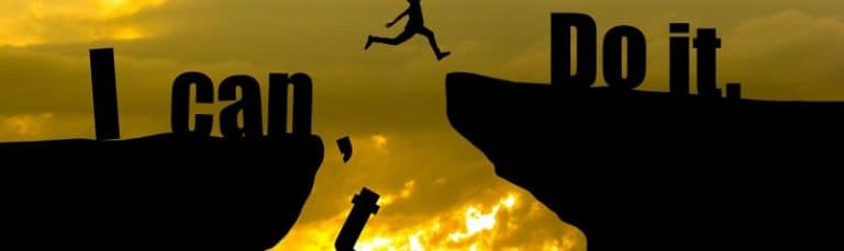 silhouette of man jumping across cliff edges