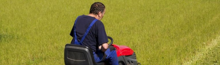 man mowing the lawn with a riding lawn mower