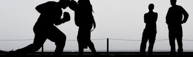 silhouette of two people boxing and two people spectating