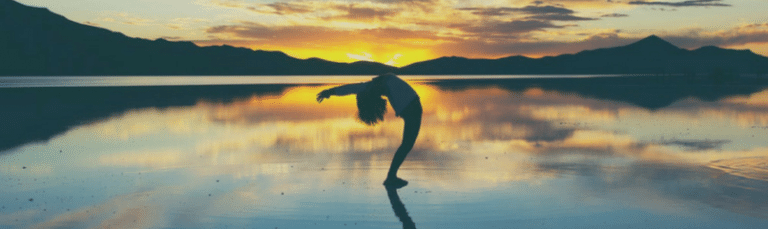 doing yoga near mountains and a sunset