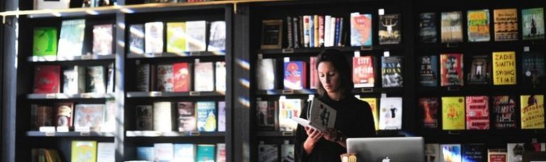 woman looking at book in bookstore