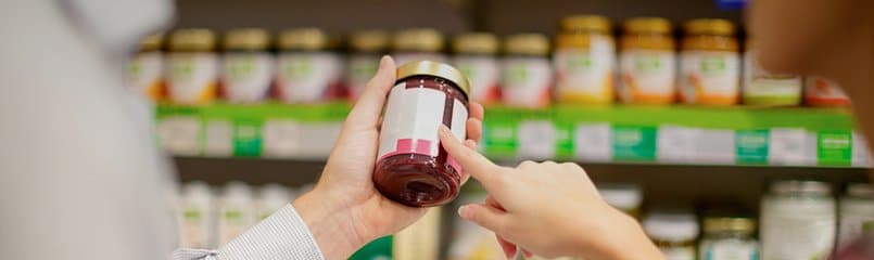 person holding a jar reading food label