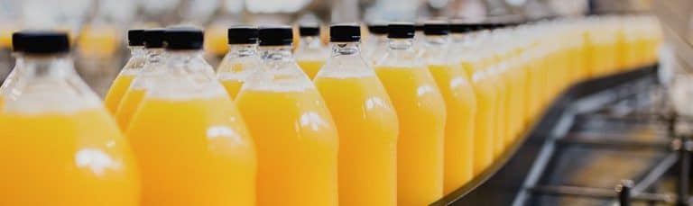 bottles of orange juice on conveyor belt